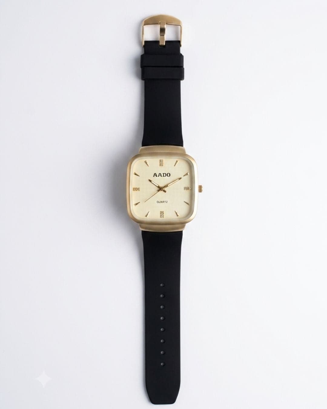 A rectangular analog watch with a gold-tone case, gold dial, and black strap, shown flat against a light gray background.